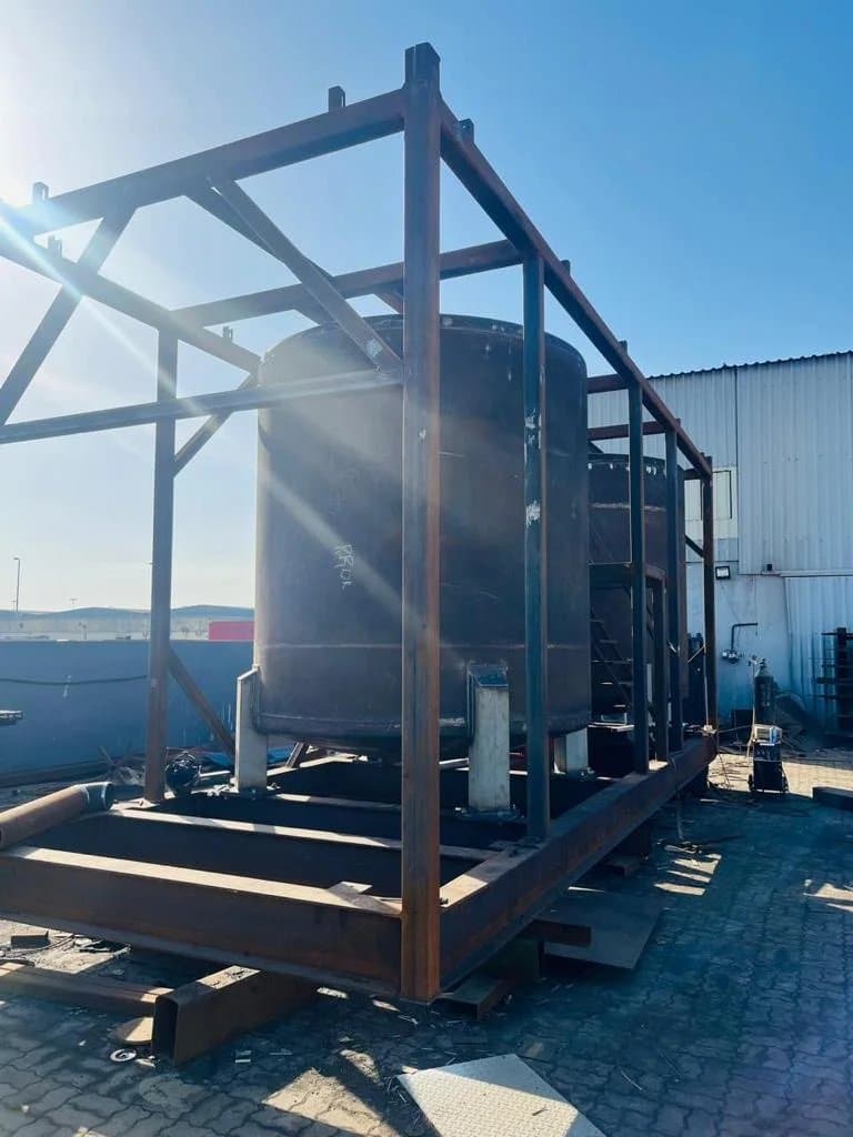 Fabricated steel frame with a vertical tank in the workshop yard